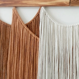 Handmade macrame wall hanging with wooden shelf and bohemian style fringe decor