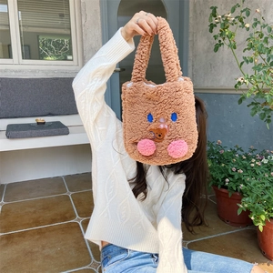 Detail of cute plush teddy handbag featuring cartoon embroidery and pink blush decor