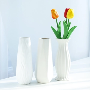 Three minimalist white ceramic vases with geometric patterns for modern home decor