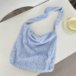Overhead view of large blue leopard print plush tote bag on white surface