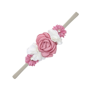 Detailed view of handmade fabric flowers on a grey nylon baby headband for photography
