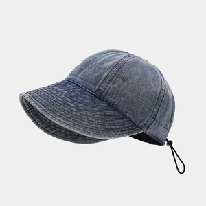 Detail of blue denim baseball cap with adjustable black drawstring and plastic toggle