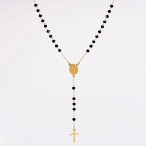 Détail d'un collier chapelet en Y avec perles noires, médaille dorée et pendentif croix