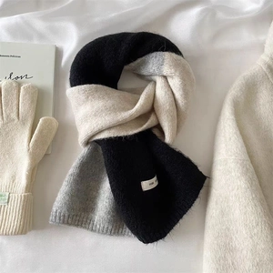 Détail d'une écharpe en tricot bicolore noir, gris et beige avec texture douce