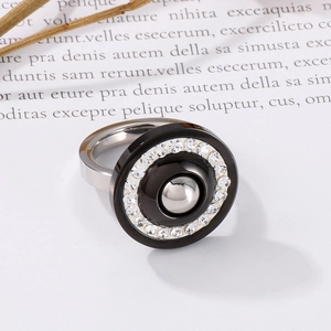 Macro detail of silver and black zircon ring with inlaid crystals on aesthetic paper