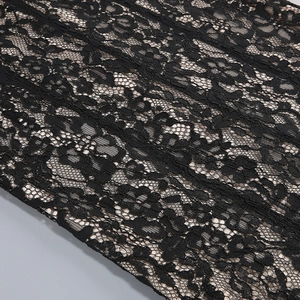 Close-up of black lace fabric showing intricate floral patterns and mesh embroidery