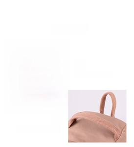 Detail of woven dual handles and logo patch on the mauve nylon travel backpack