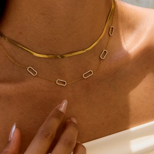 Close-up of golden stainless steel snake chain and zircon rectangle pendant necklace
