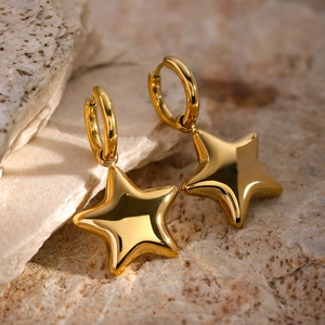 Polished 18k gold plated stainless steel star hoop earrings on a textured stone surface