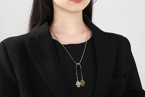 Détail du collier chaîne serpent dorée avec double pendentif Main de Fatma sur modèle