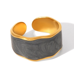 Close-up of golden irregular open ring with dark grey enamel and sand texture finish
