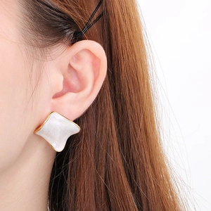 Elegant white enamel square earrings with gold trim on model for a minimalist look