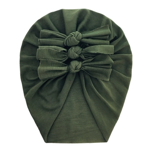 Detail of soft green cotton baby turban hat with three decorative knotted bows on front