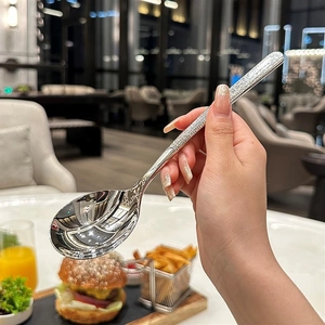 Détail de la texture martelée du manche de cuillère en acier inox dans un restaurant