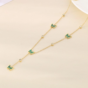 Close-up of gold chain with green butterfly pendants and sparkling zircon accents