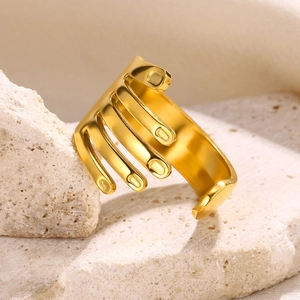 Macro view of gold-plated multi-layer open ring on travertine stone textured base