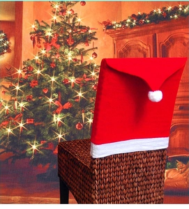 Close-up of a red Christmas hat chair cover with white pompom on a wicker chair