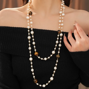 Detail of elegant double-layer necklace with white pearls and brown tiger eye beads