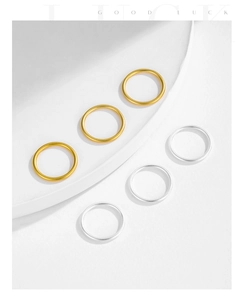 Close-up of minimalist gold and silver stacked rings with frosted sandblast texture