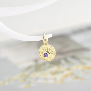 Golden round evil eye pendant with purple zircon inlay and sunburst engraving detail