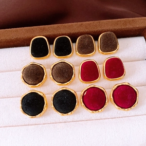 Collection of vintage velvet geometric earrings in gold setting displayed on a tray