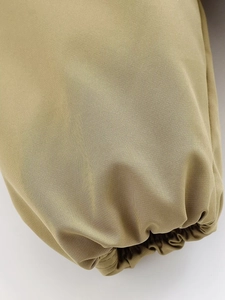Détail de la manche d'une veste kaki avec poignet élastique et texture en sergé de coton