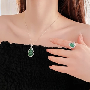 Detail of green hulu pendant necklace and matching ring with zircon inlay set on model