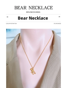 Close-up of polished 18k gold plated titanium steel bear pendant necklace on a model