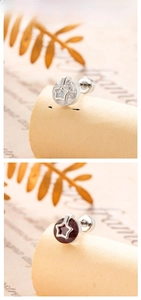 Detailed view of 6mm hollow star stud earrings with white and red cubic zirconia gems