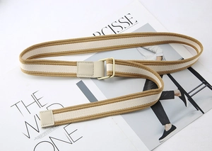 Detail of striped canvas belt with D-ring buckle and leather end on fashion magazine