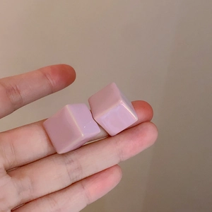 Dettaglio degli orecchini a fiore con pietra occhio di gatto rosa e finitura perlata