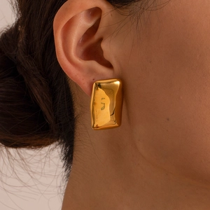 Detailed close-up of rectangular gold earrings with textured liquid metal finish on model