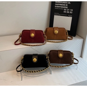 Detail view of four vintage doctor bags in matte leather with gold relief metal buckles