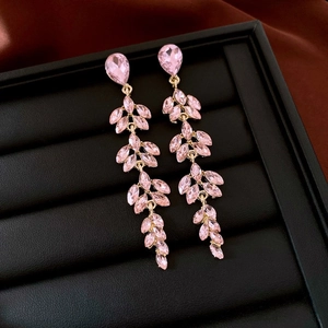Detailed close-up of pink crystal tassel earrings with leaf-shaped stones on black display