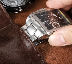 Dettaglio di un orologio inserito in una custodia in pelle cerata marrone per il viaggio