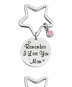 Close-up of stainless steel keychain with pink gemstone and engraved heart message