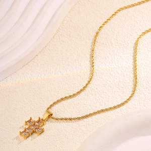 Close-up of gold twist chain necklace with a sparkling zircon inlaid cross pendant