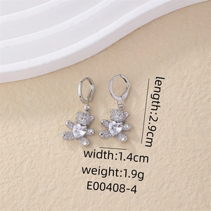 Macro view of silver bear earrings with white zircon and heart stone details