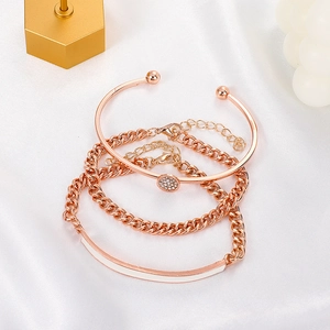 Three-piece punk rose gold geometric bracelet set with rhinestones on satin background