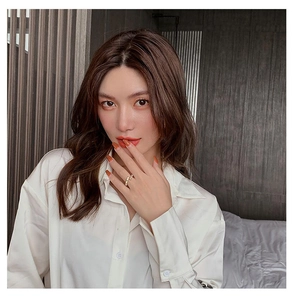 Detail of bamboo style golden ring with zircons worn with a white satin shirt