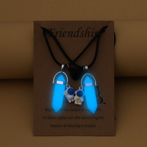 Luminous astronaut couple necklaces with blue hexagonal glowing pendants on friendship card