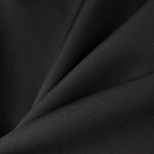 Macro shot of high-quality black suit fabric texture with detailed weave and soft folds