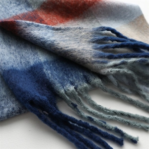 Detailed view of soft brushed plaid scarf with colorful fringes and woven texture