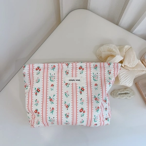 Détail d'une trousse en coton floral avec rayures roses et étiquette simple wish