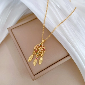 Detail of golden dreamcatcher necklace with colorful gemstones and three feather charms