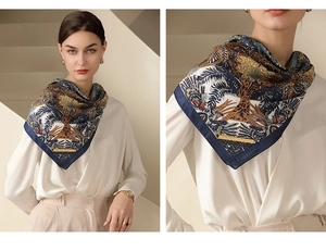 Detail of navy and gold floral print silk scarf with intricate tropical tree patterns