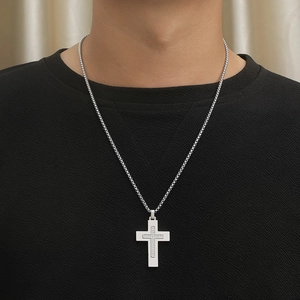 Close-up of a silver cross pendant with CNC cubic zirconia on a box chain for men
