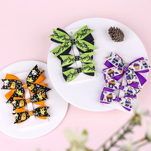 Detailed view of Halloween bow hair clips set with pumpkin, ghost, and spider patterns