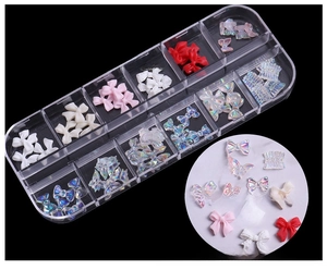 Detailed view of Aurora resin butterfly nail art charms in a 12-grid storage container