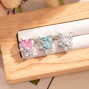 Three pairs of heart shaped zircon stud earrings in pink, blue, and white tones